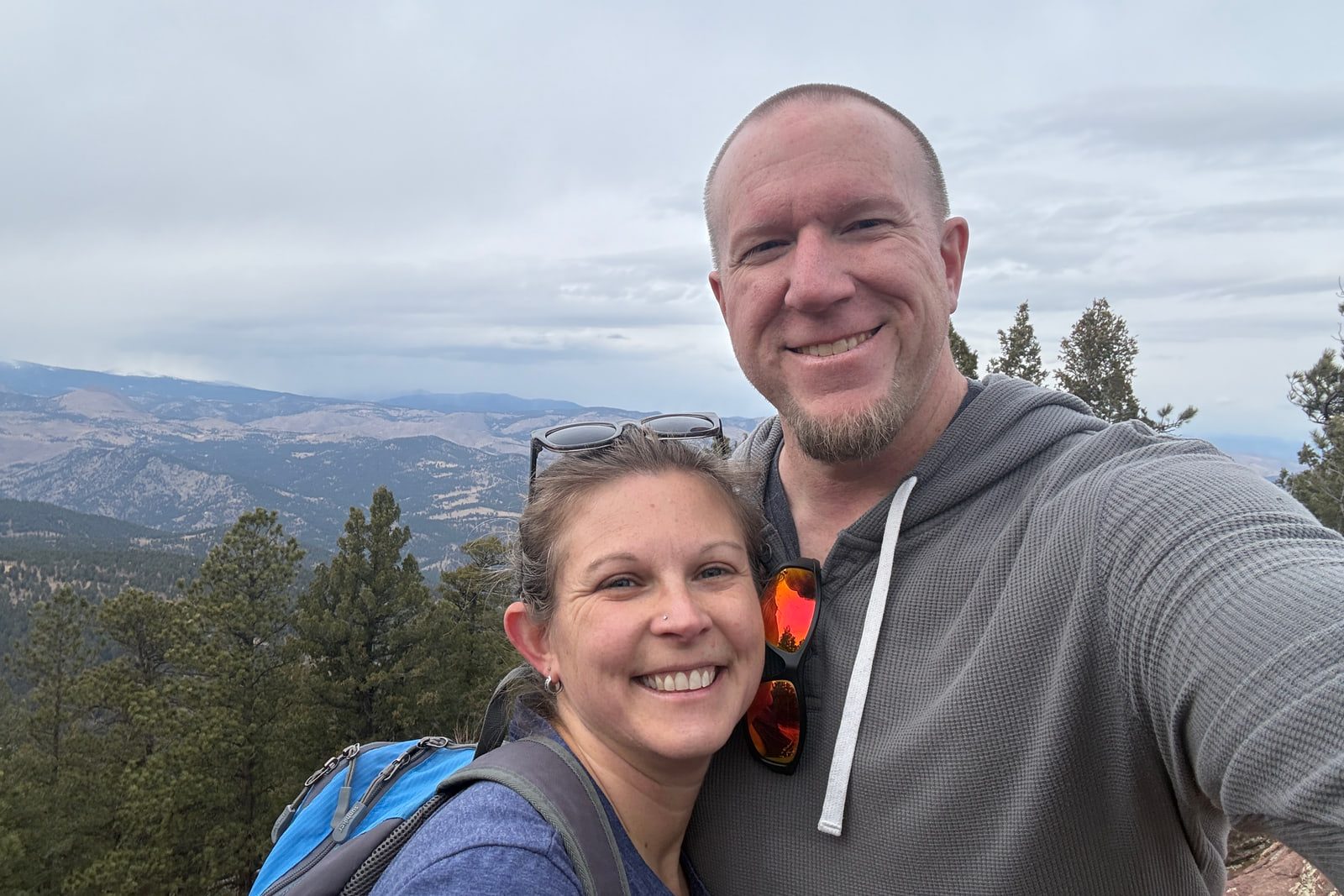 Aaron and Mindy Lerch outdoors on a trail above Boulder, with the foothills behind them.